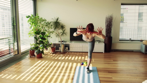 Beautiful young fitness woman doing exercise at home.