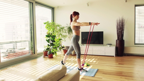 Beautiful young fitness woman doing exercise at home.