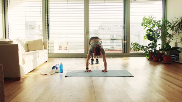 Beautiful young fitness woman doing exercise at home.