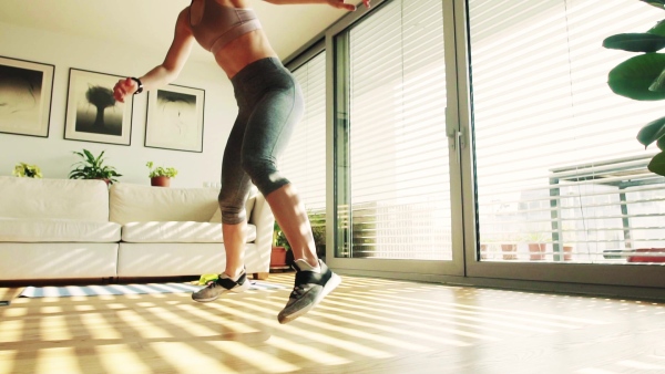 Beautiful young fitness woman doing exercise at home. Slow motion.