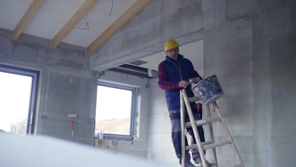 Accident of a male worker at the construction site. A man falling off the ladder. Slow motion.