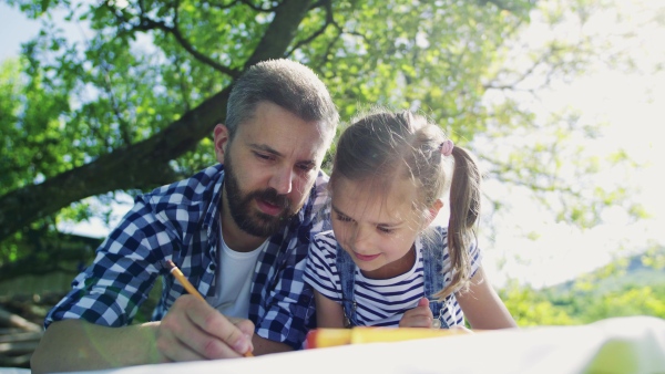 Father with a small daughter outside, drawing or making sketches.