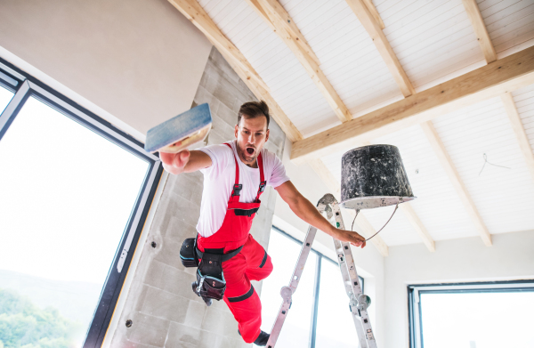 Accident of a male worker at the construction site. A man falling off the ladder.