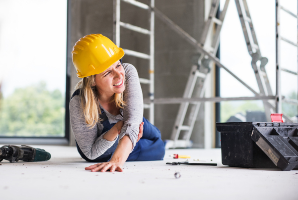 Accident of a female worker at the construction site. An injured woman on the floor.