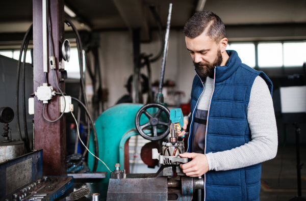 Mature man mechanic repairing a car in a garage.