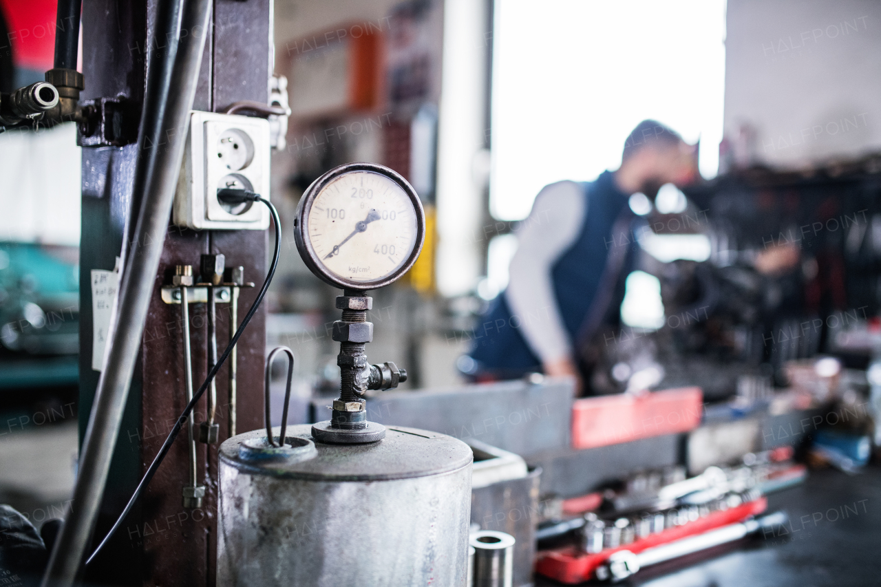 Unrecognizable man mechanic repairing a car in a garage.