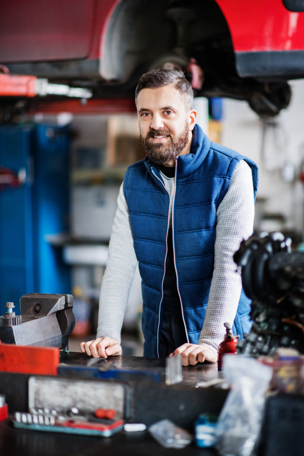 Portrait of a man mechanic in a car garage.