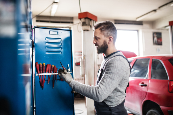 Portrait of a man mechanic standing in a garage.