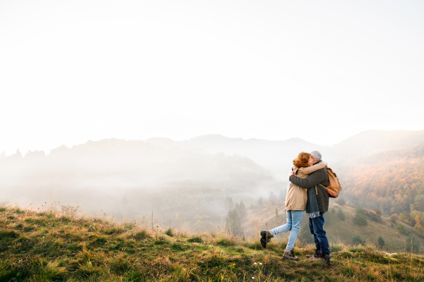 Active senior couple on a walk in a beautiful autumn nature.