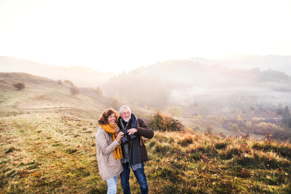 Active senior couple on a walk in a beautiful autumn nature.