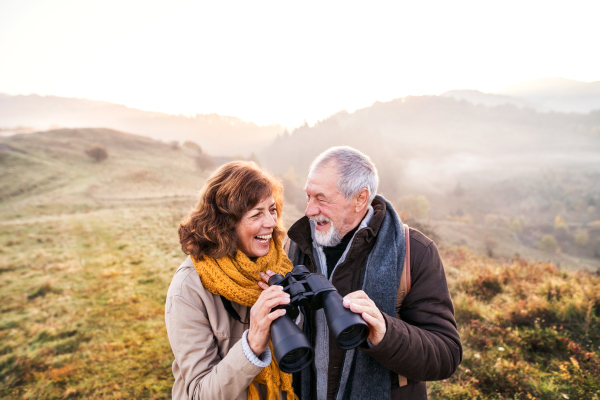 Active senior couple on a walk in a beautiful autumn nature.