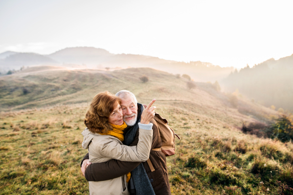 Active senior couple on a walk in a beautiful autumn nature.