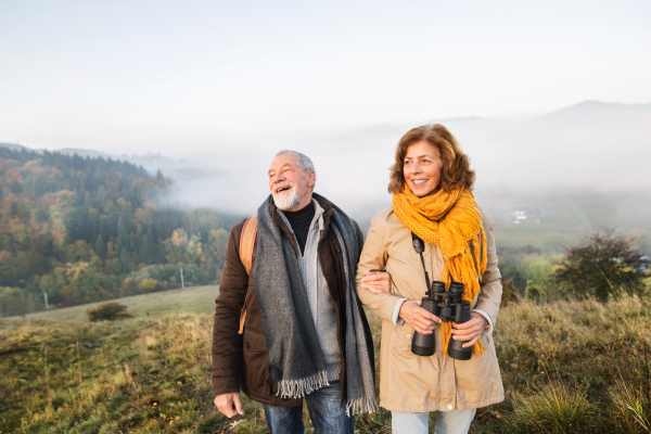 Active senior couple on a walk in a beautiful autumn nature.