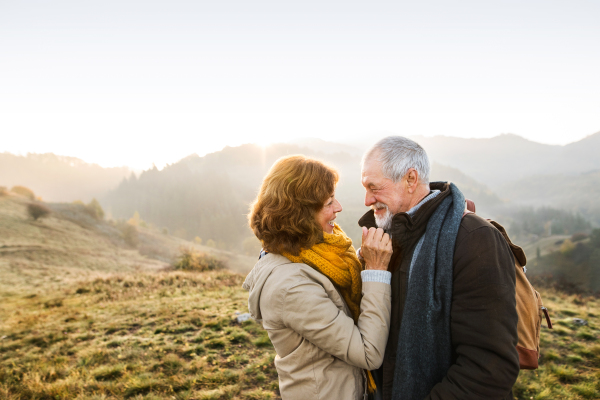 Active senior couple on a walk in a beautiful autumn nature.