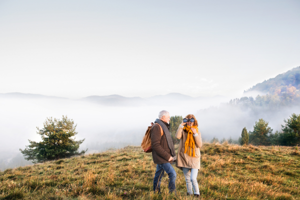 Active senior couple on a walk in a beautiful autumn nature.