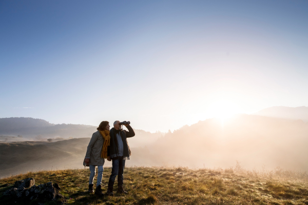 Active senior couple on a walk in a beautiful autumn nature.