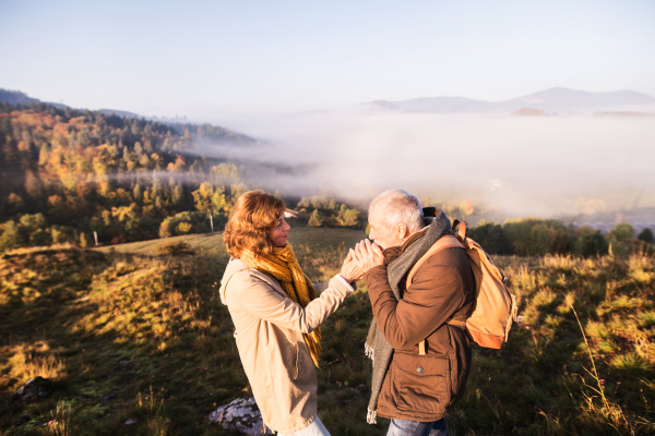 Active senior couple on a walk in a beautiful autumn nature.