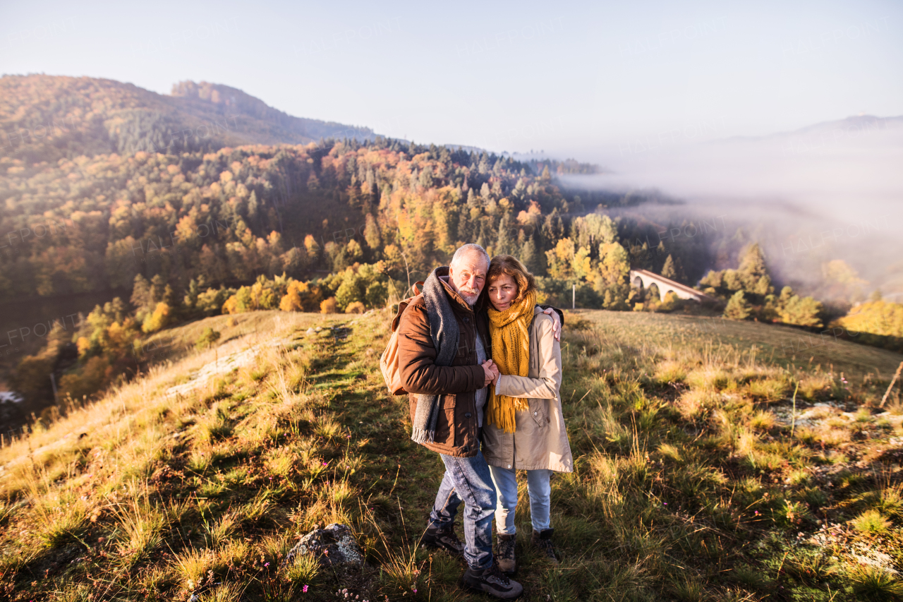 Active senior couple on a walk in a beautiful autumn nature.