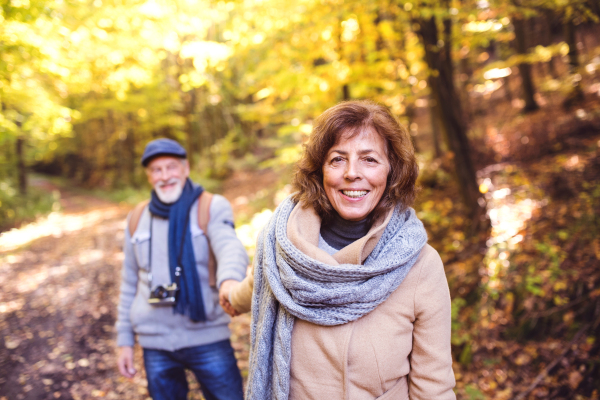 Active senior couple on a walk in a beautiful autumn nature.