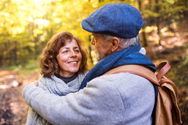 Active senior couple on a walk in a beautiful autumn nature.