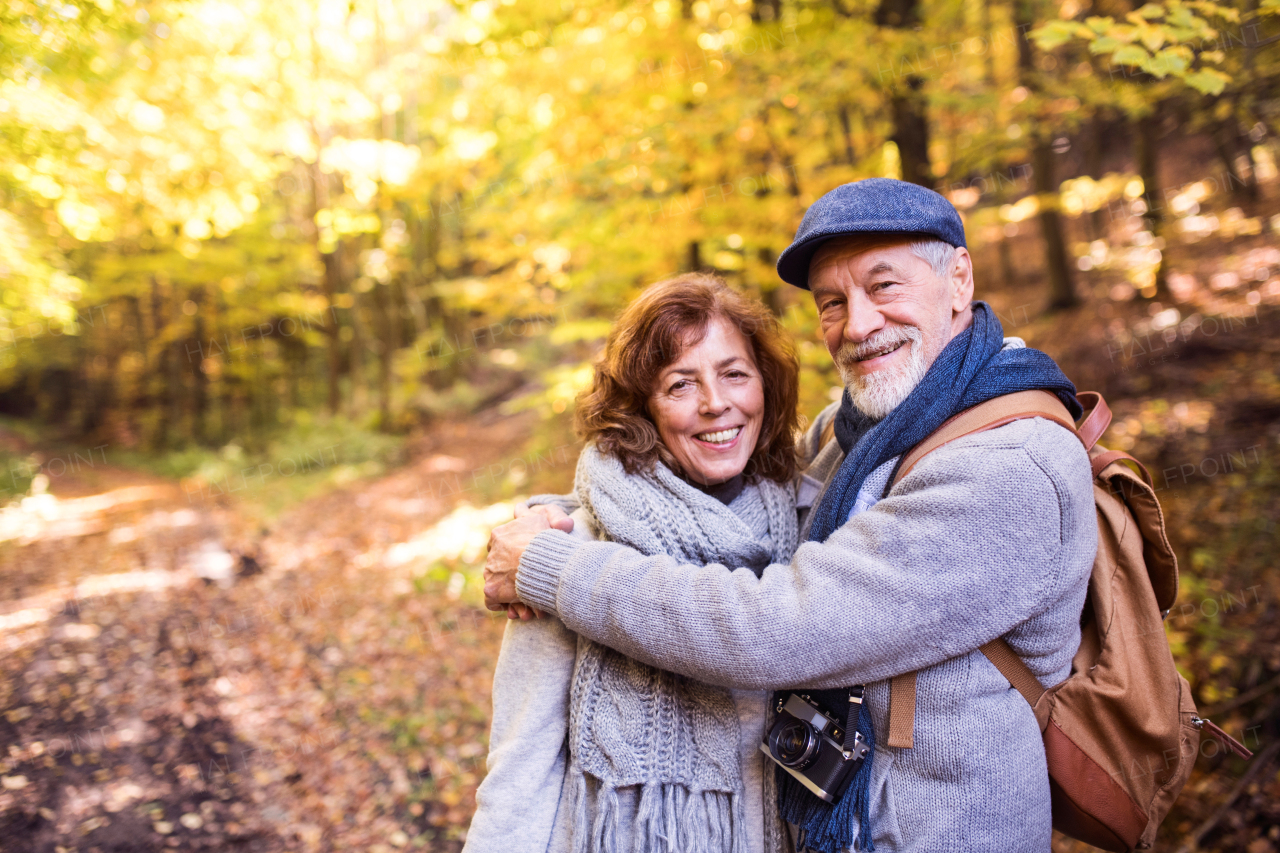 Active senior couple on a walk in a beautiful autumn nature.