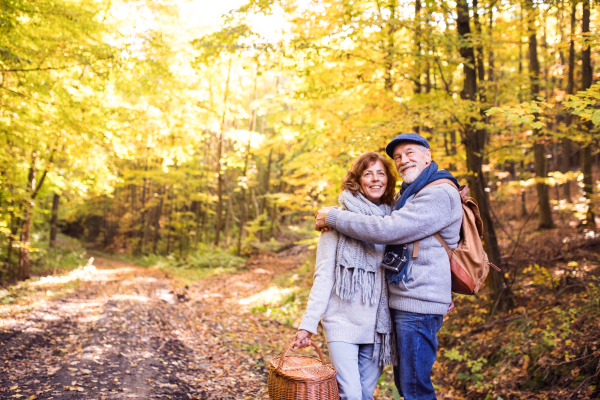 Active senior couple on a walk in a beautiful autumn nature.