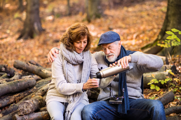 Active senior couple on a walk in a beautiful autumn nature.