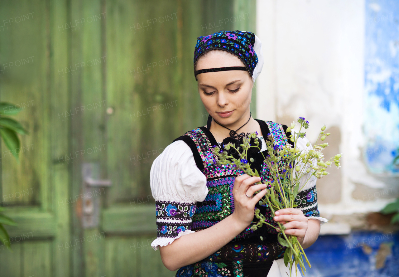 Portrait of young beautiful woman in traditional folk dress outdoors.