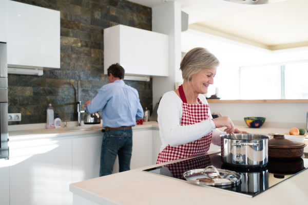 Senior woman and man in the kitchen cooking together.