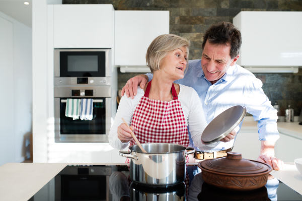 Senior woman and man in the kitchen cooking together.