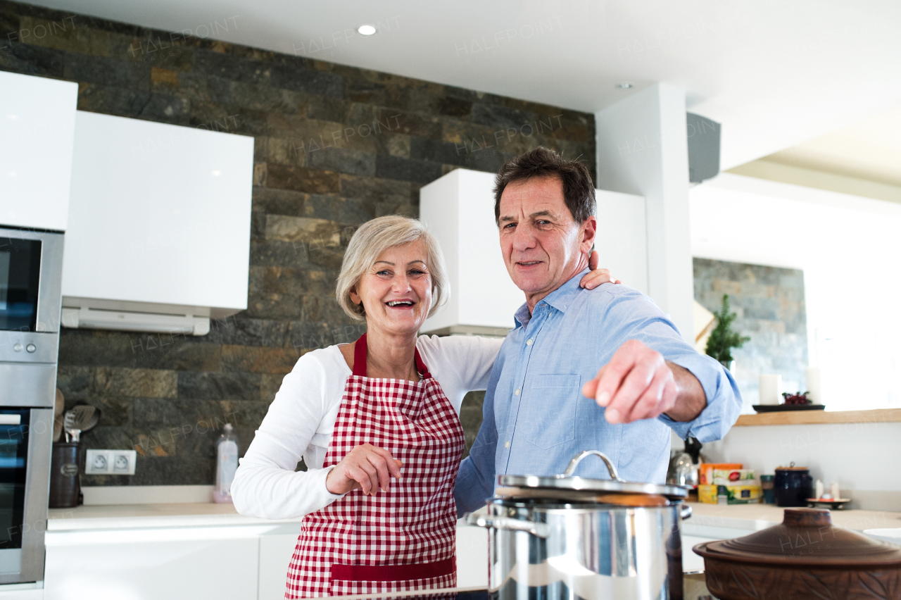 Senior woman and man in the kitchen cooking together.