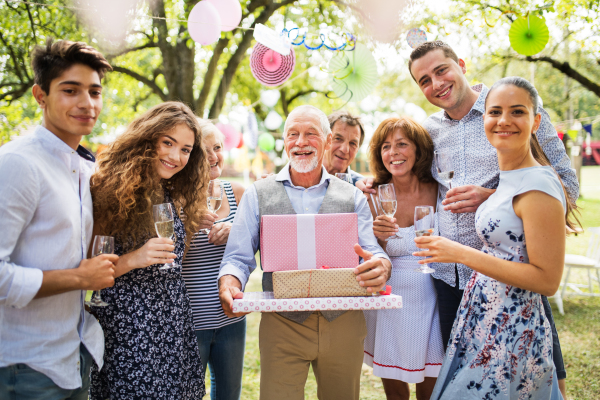 Family celebration outside in the backyard. Big garden party. Birthday party of a senior man.