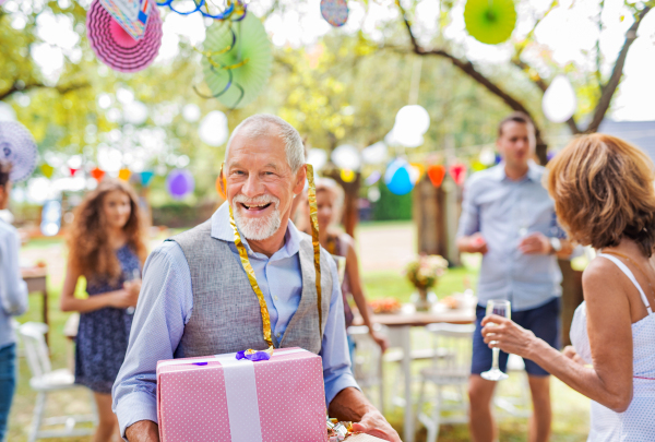 Family celebration outside in the backyard. Big garden party. Birthday party of a senior man.