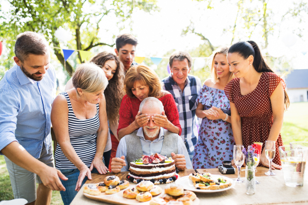 Family celebration outside in the backyard. Big garden party. Birthday party of a senior man.