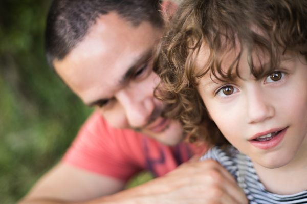 Young father with his cute little son. Sunny summer day in nature. Close up.