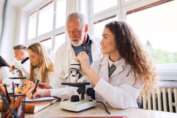 Senior teacher teaching biology to his high school students in laboratory.