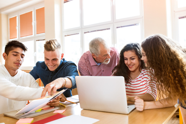 Group of high school student and their teacher with laptop studying.