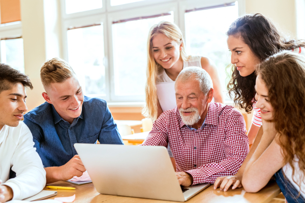 Group of high school student and their teacher with laptop studying.