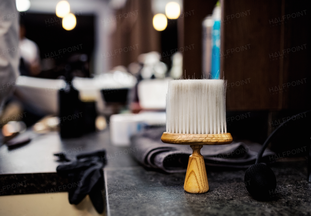 A hair dust brush and other tools in hair salon for men, barbershop interior. Copy space.