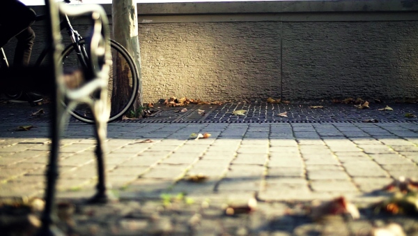 A midsection of unrecognizable businessman commuter with electric bicycle traveling to or from work in city. Slow motion.