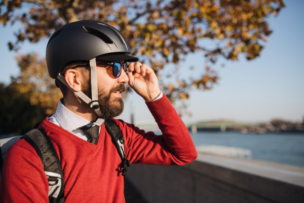 Hipster businessman commuter with bicycle traveling to work in city. Copy space.