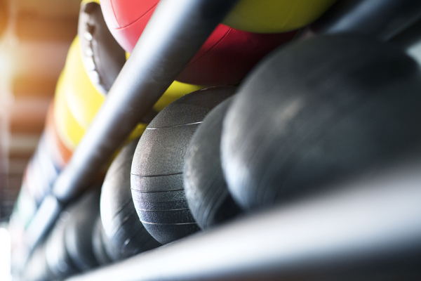 Close up of medicine balls on shelf in modern gym. Weight training equipment.