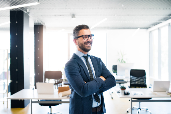 Young hipster businessman with tie and eyeglasses in the office smiling.