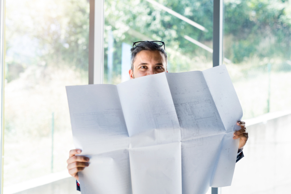 Handsome young businessman in his office studying plans.