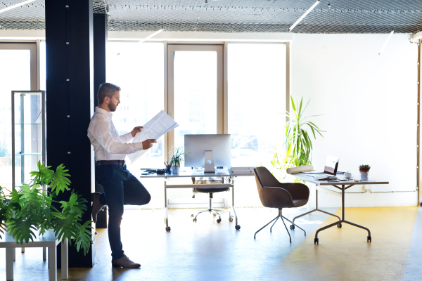 Handsome young businessman in his office studying plans.