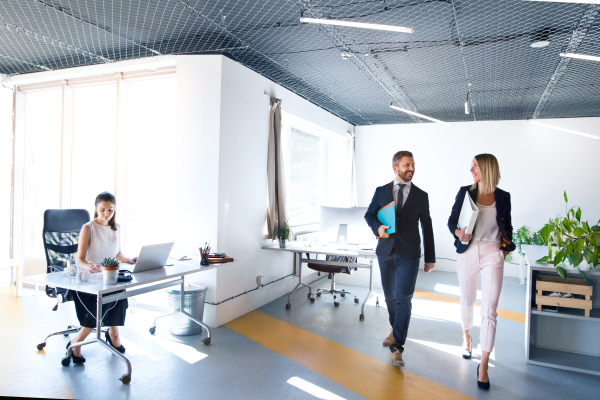 Beautiful young business people in the office. Man and woman going to a meeting.