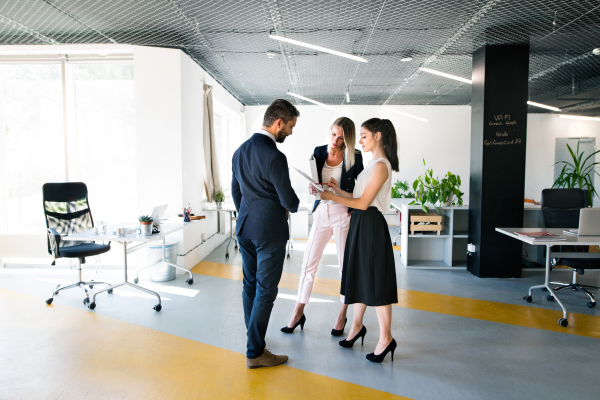 Beautiful young business people in the office. Man and woman shaking hands.