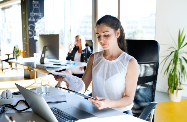 Two attractive young business women in the office working.