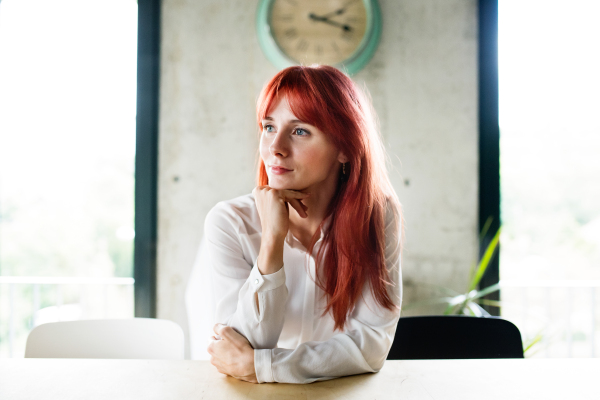 Beautiful young businesswoman sittning at desk in her office.