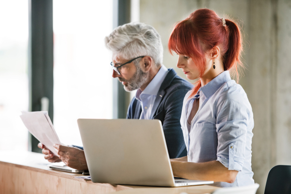 Two business people in workplace. Woman and man in creative office consulting a project together.